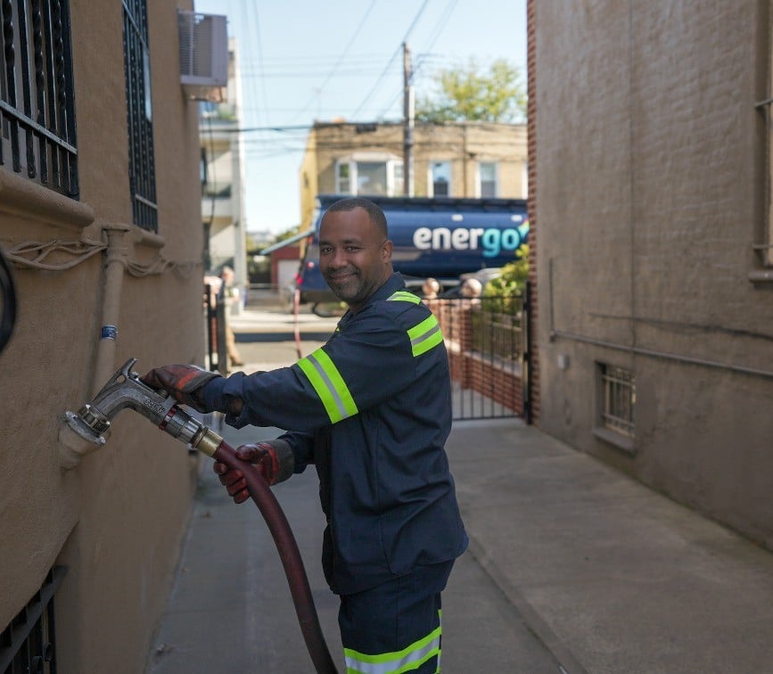 Energo employee wearing gloves with hose over shoulder