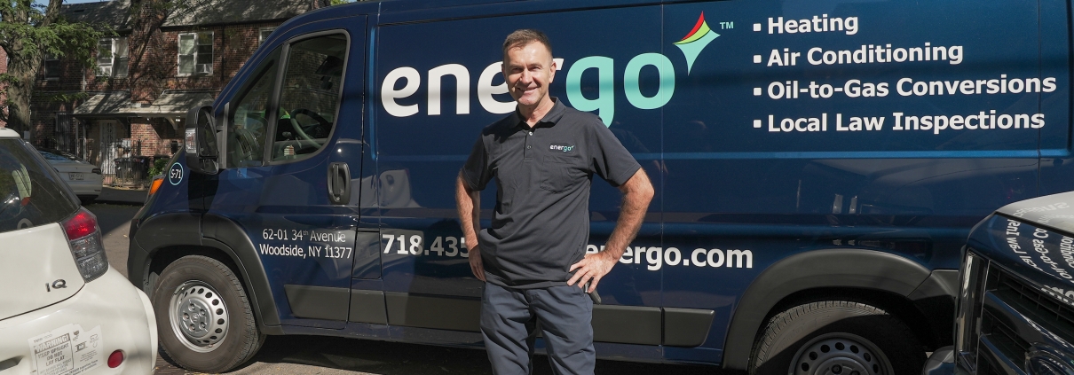 Energo employee standing in front of van with hands on hips