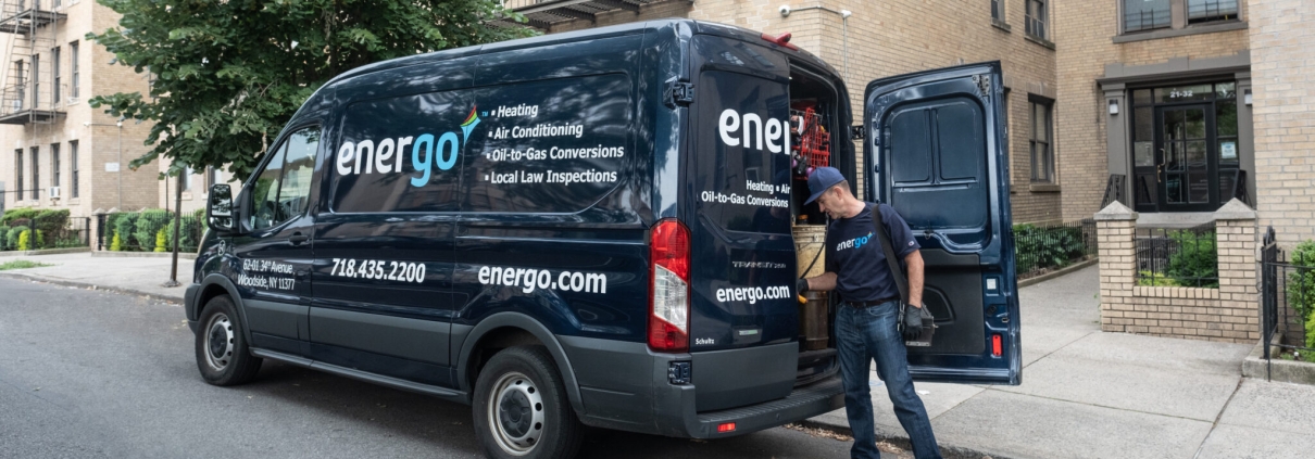 Energo service van parked on NYC street, technician standing nearby