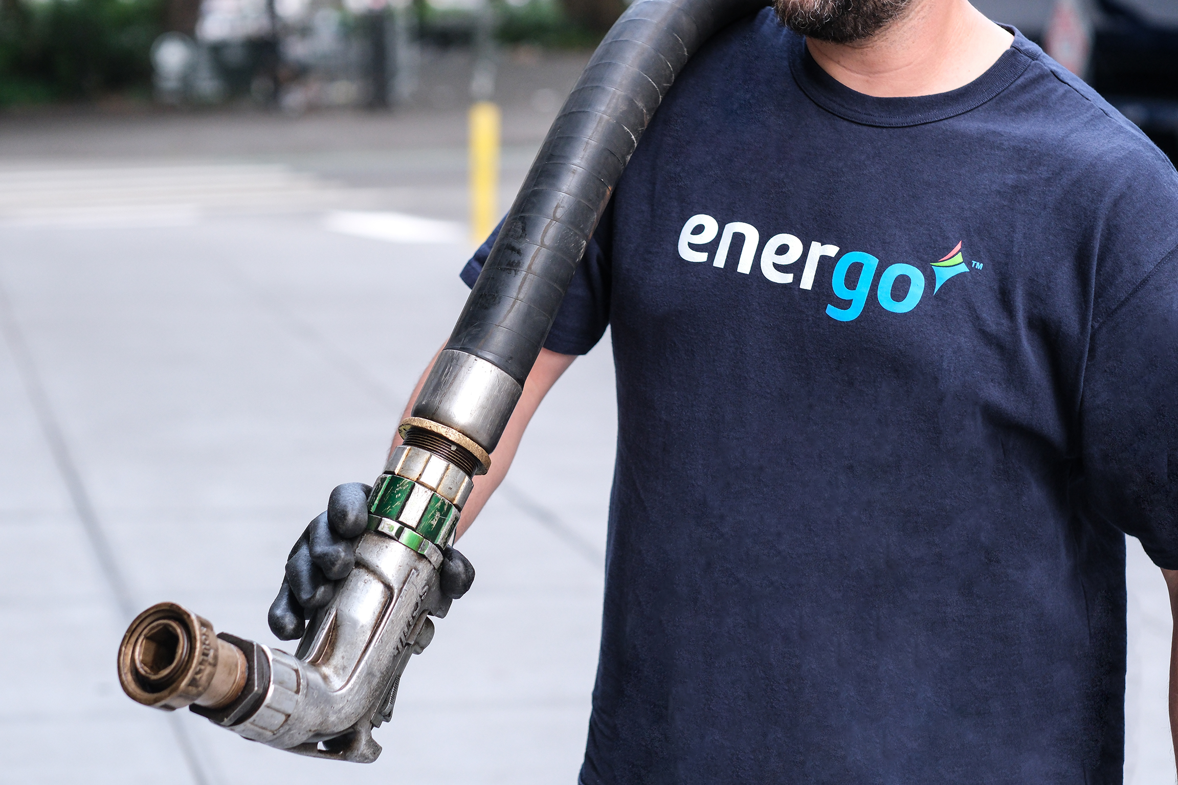 Energo employee wearing gloves with hose over shoulder
