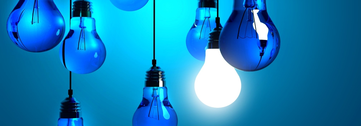Blue lightbulbs with one glowing bright, symbolizing energy efficiency