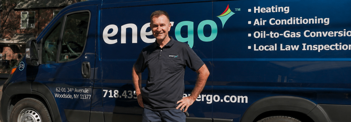 Energo technician unloading tools from branded service van parked curbside