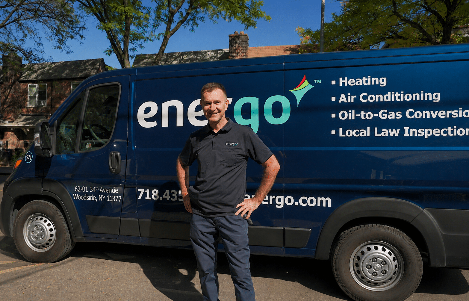 Energo technician unloading tools from branded service van parked curbside