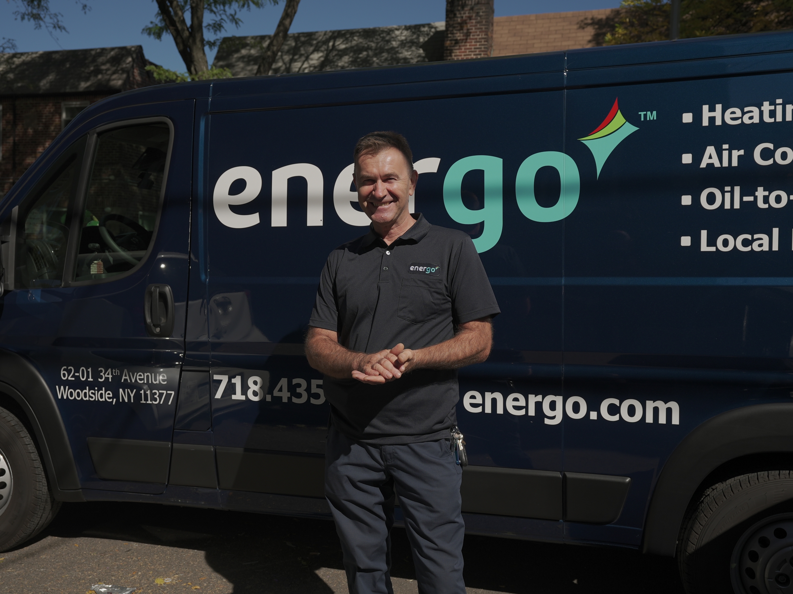 Energo technician standing by branded service van smiling