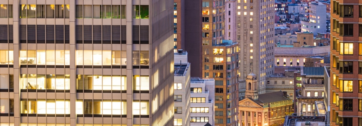 NYC office building exterior lit up at night