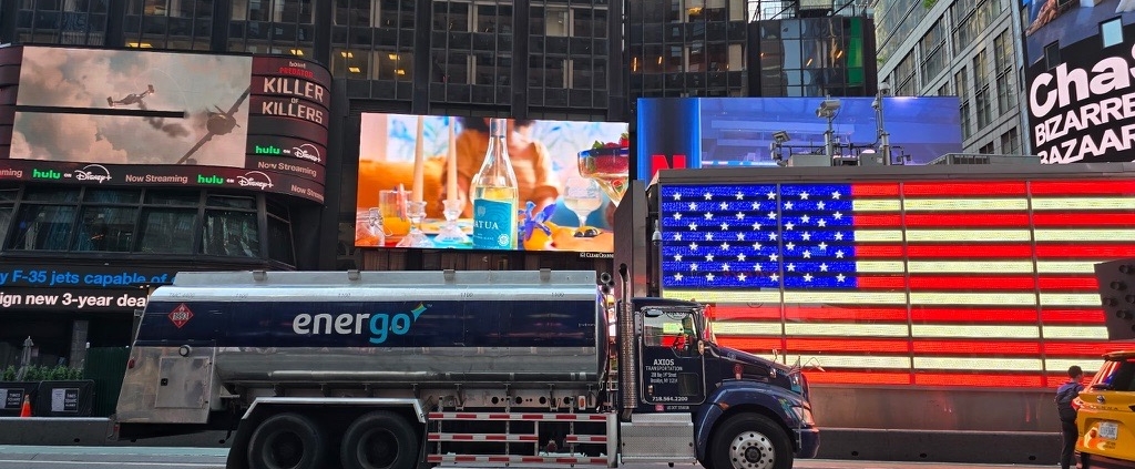 Energo oil delivery truck driving through Times Square with digital billboards