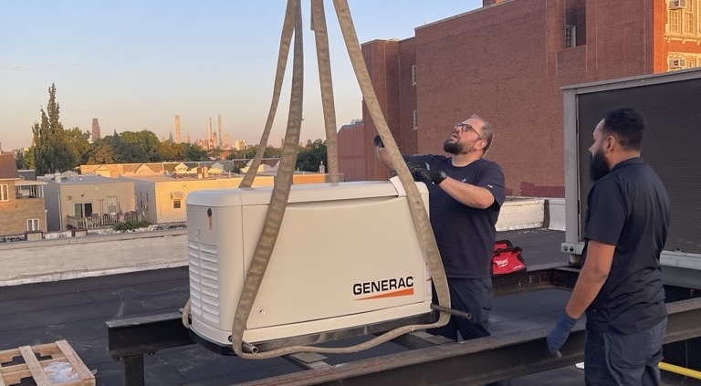 Generac generator being lifted by crane onto rooftop installation