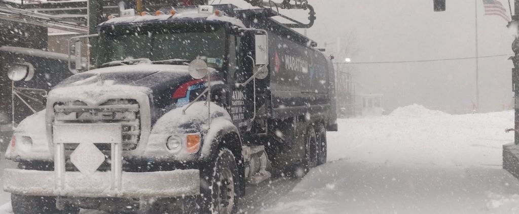 Energo heating oil truck driving through snowy weather conditions