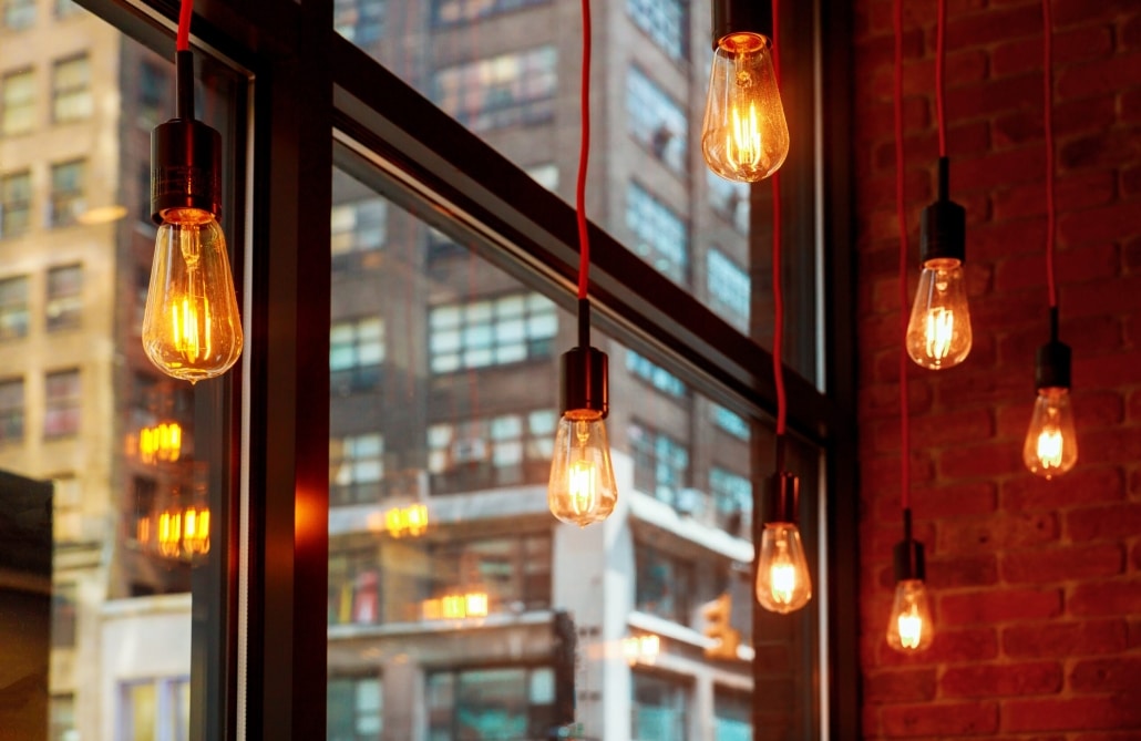 Edison bulbs in front of window with city reflections
