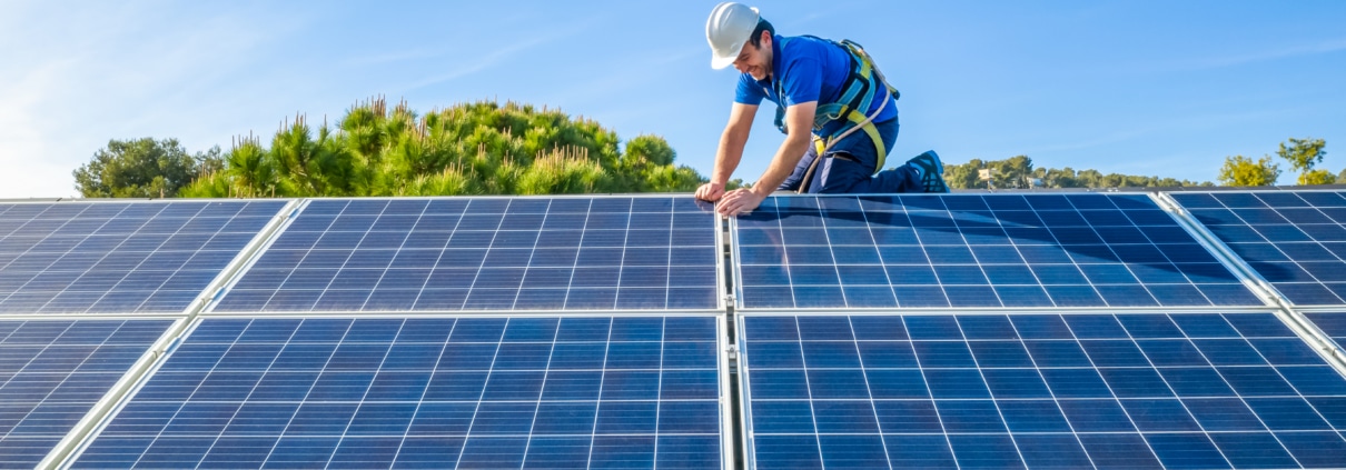 Technician working on rooftop solar panels