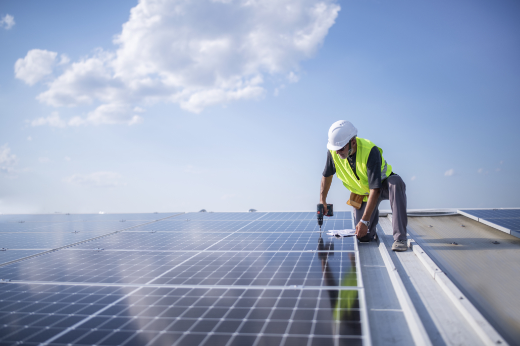 Worker cleaning rooftop solar panels