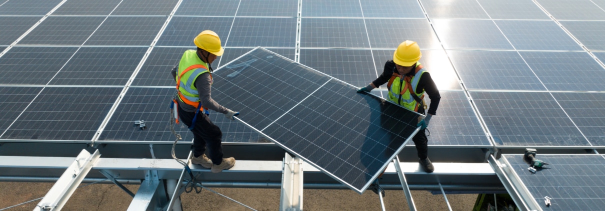 Solar technicians installing panels on a commercial rooftop