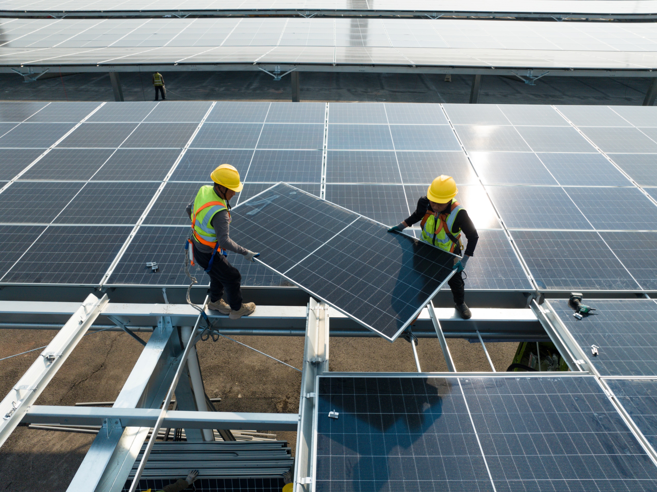 Solar technicians installing panels on a commercial rooftop