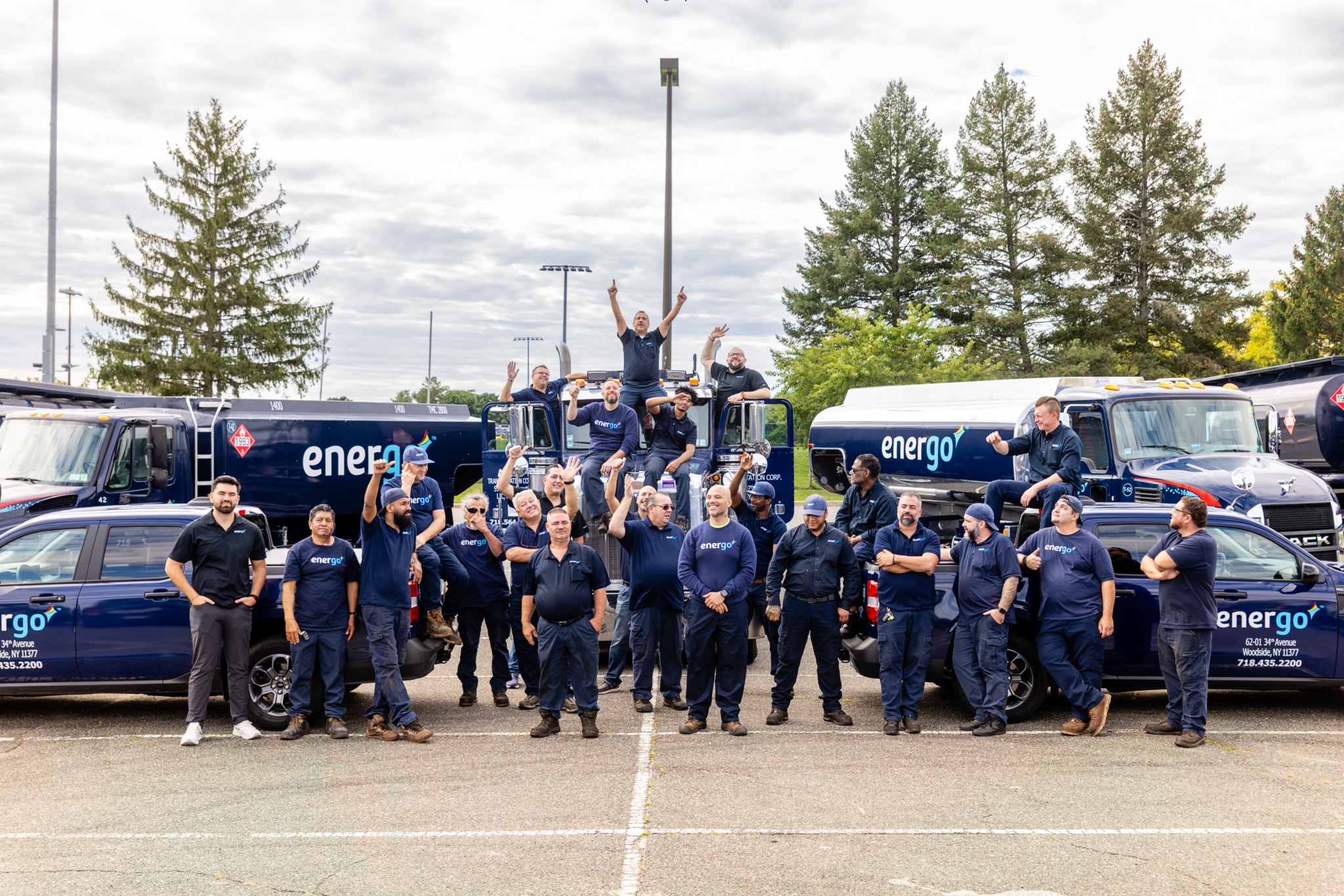 Energo team posing together with branded pickup trucks and fuel delivery tankers