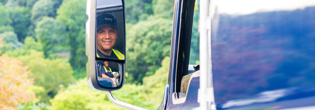 Energo delivery driver reflected in the side mirror of a branded fuel truck