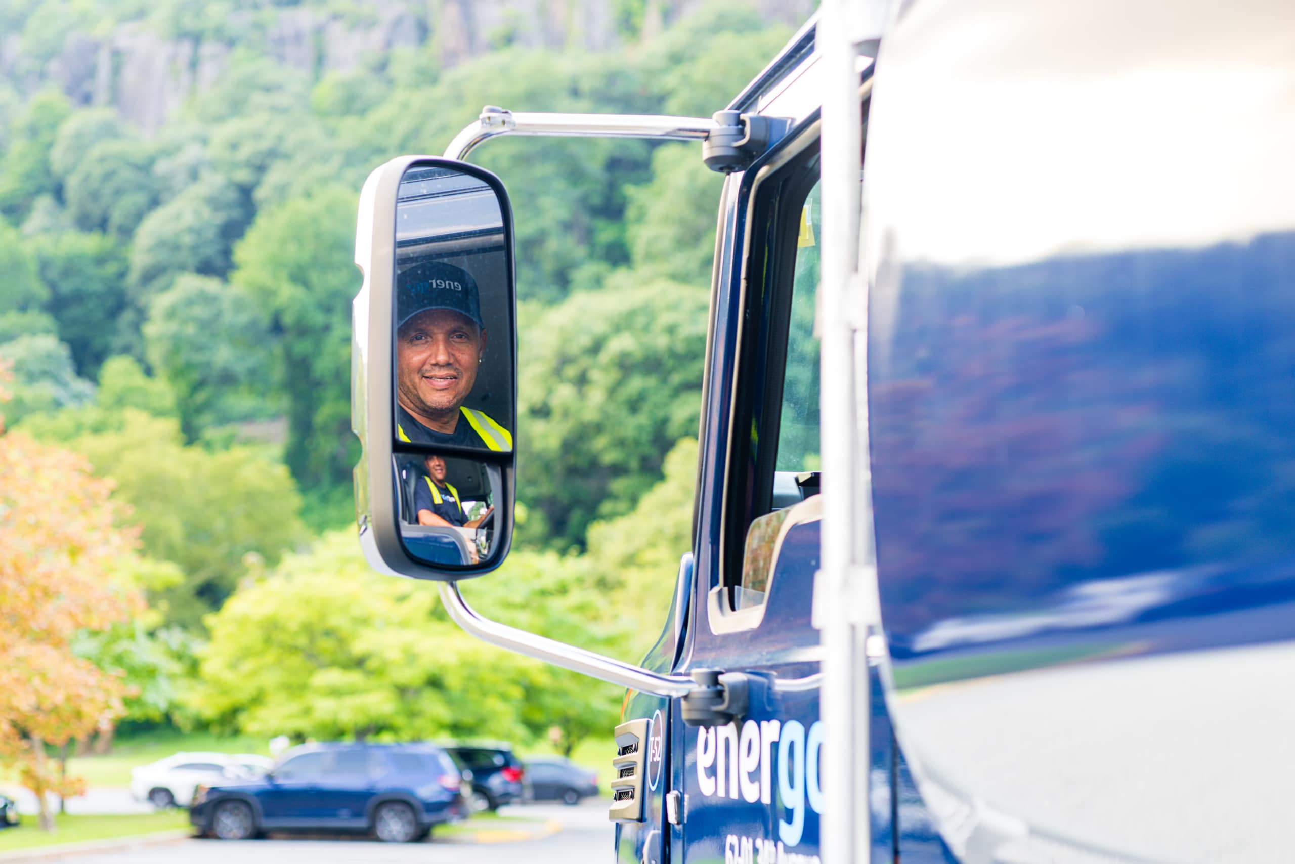 Energo delivery driver reflected in the side mirror of a branded fuel truck