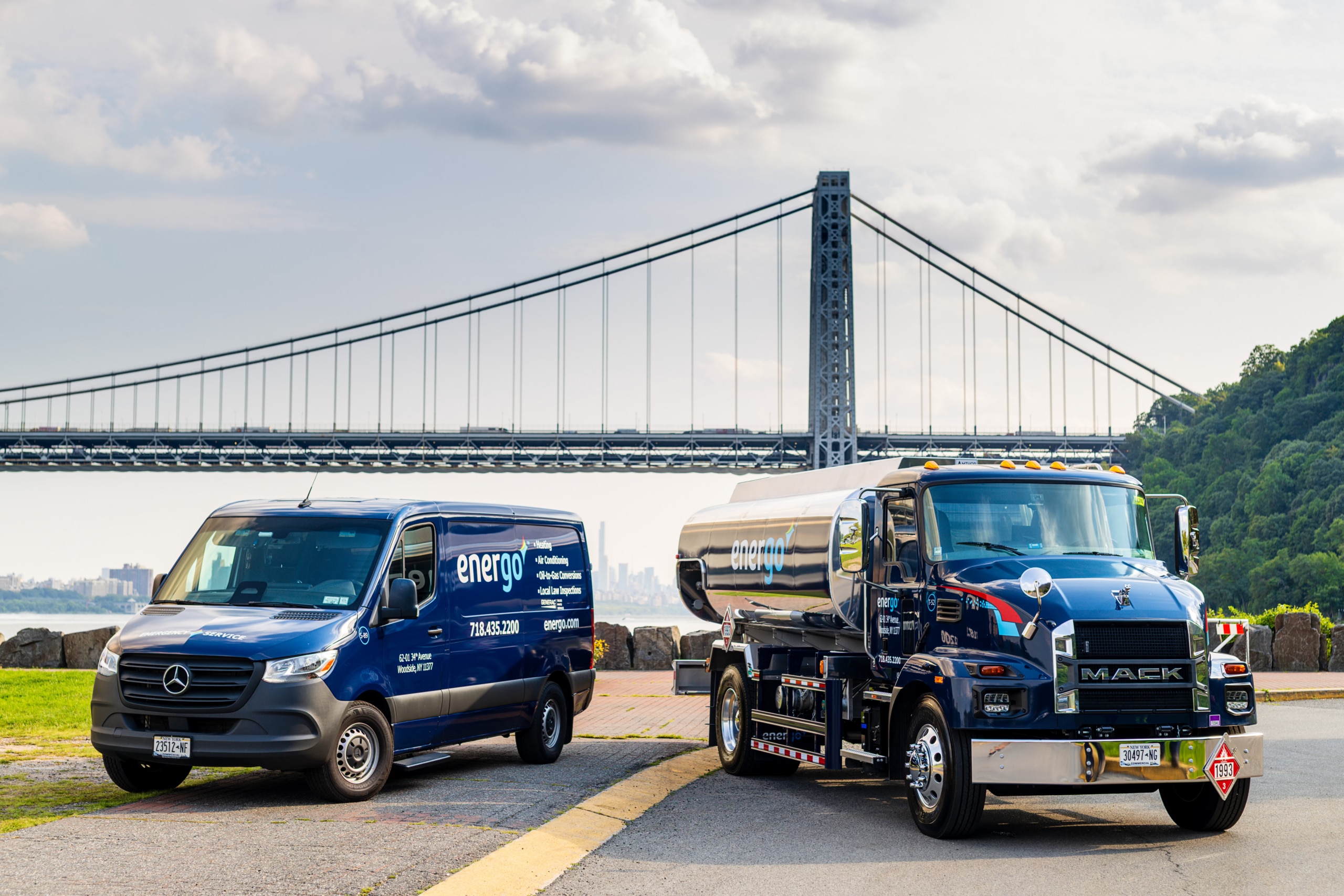 Energo service van and heating oil tanker parked together beneath a suspension bridge